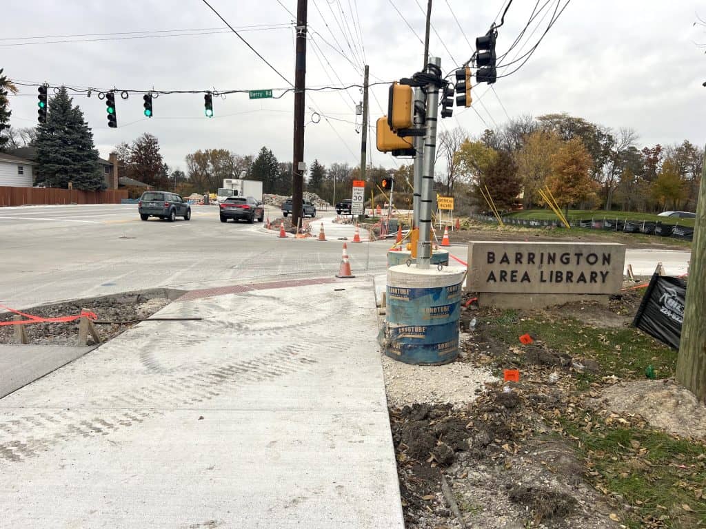 Construction zone on suburban Chicago bike-friendly street, Barrington Area Library nearby, ongoing road improvements, traffic signals and pedestrian pathways.