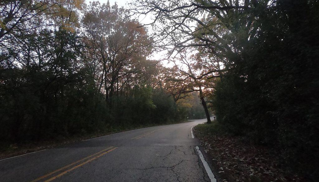 Scenic bike path surrounded by trees in suburban Chicago with sunset sky.
