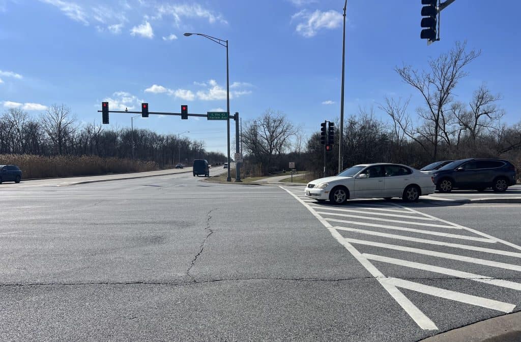 A busy street intersection with traffic lights and cars, near Tinley Creek trails.