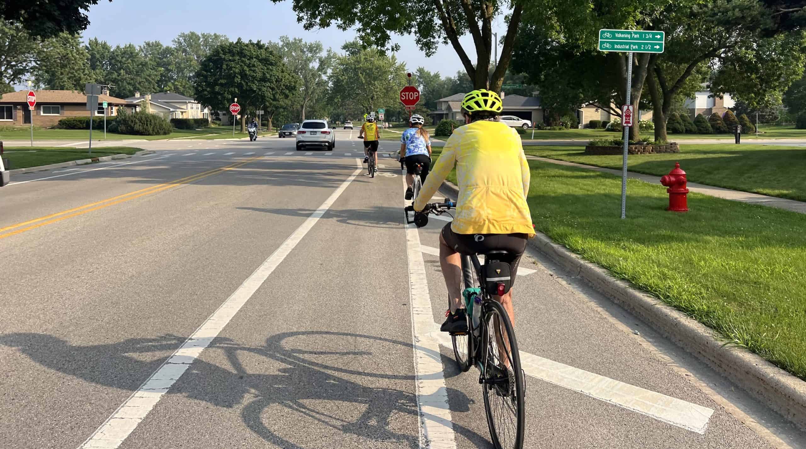 Cyclist riding on suburban street during National Bike Month in May, Chicago suburbs.