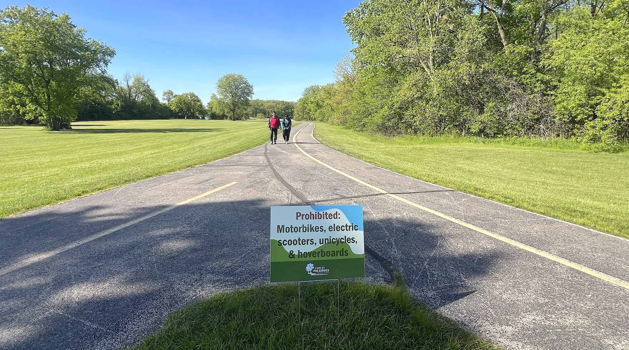 Enjoying a scenic bike ride on a paved trail in suburban Chicago with lush greenery.