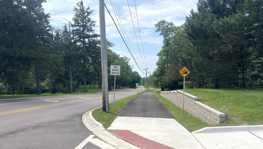 Quiet suburban sidewalk with trees and road in Dundee Township, Illinois.