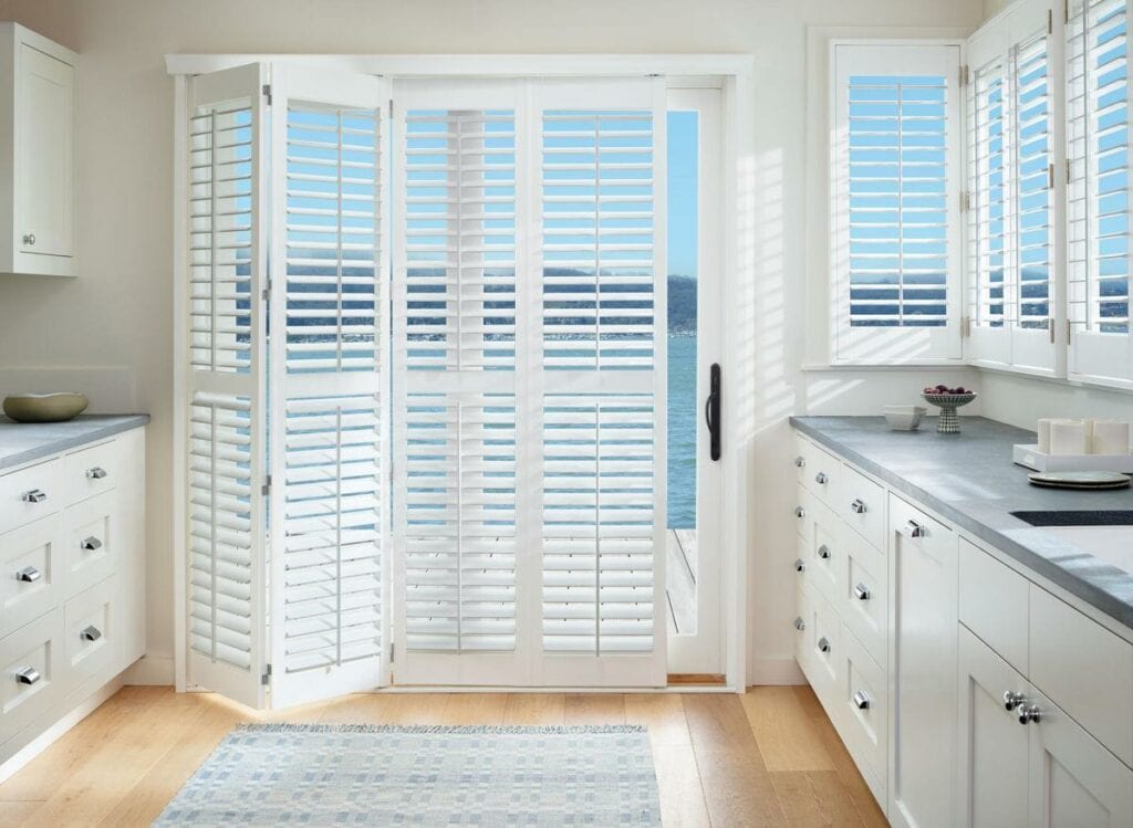 White custom sun shades with plantation shutters for windows and sliding doors.