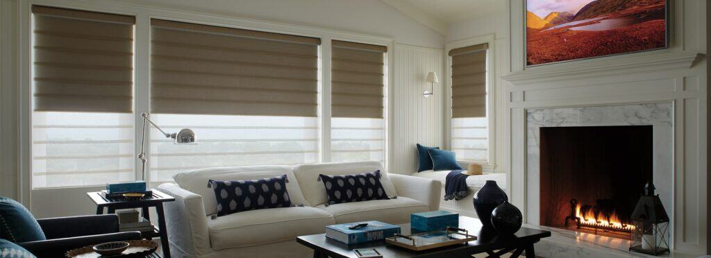 Soft pink roller sun shades for window privacy and light control in a cozy sunroom.