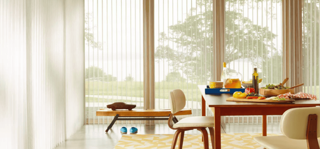 Soft pink roller sun shades for window privacy and light control in a cozy sunroom.