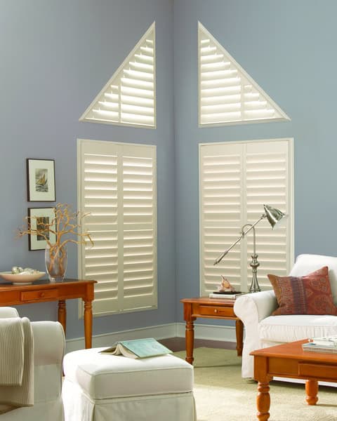 White custom window shades and shutters in a modern living room for sun protection and style.