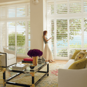 Sun shades window fashions with stylish plantation shutters and window coverings in a bright living room.