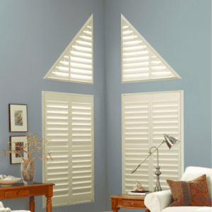 White custom window shutters with triangular and rectangular designs, enhancing room privacy and style.