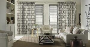 Luxurious window shades in a contemporary living room with beige sofas and patterned curtains.