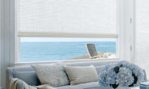 Sun shades window fashions with ocean view in a bright modern room, showcasing stylish window coverings.