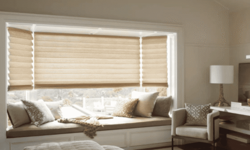 Bright window seat with beige blinds, plush cushions, and a cozy blanket in a well-lit living room.