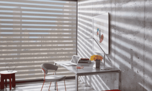 Bright modern office with a desk, chair, laptop, and colorful artwork, illuminated by sunlight creating striped shadow patterns on the wall and floor.