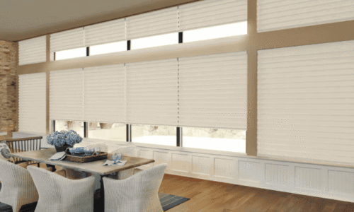 Modern apartment with white horizontal blinds covering large windows, natural light, cozy dining area, and wooden flooring.