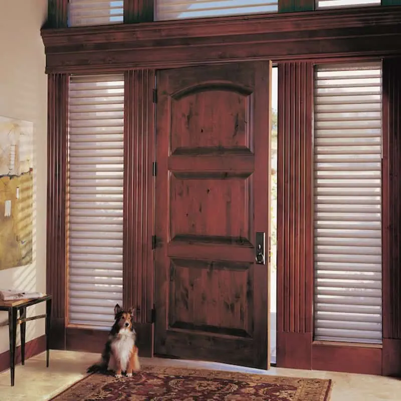 Elegant wooden front door with shutters in a cozy home interior.