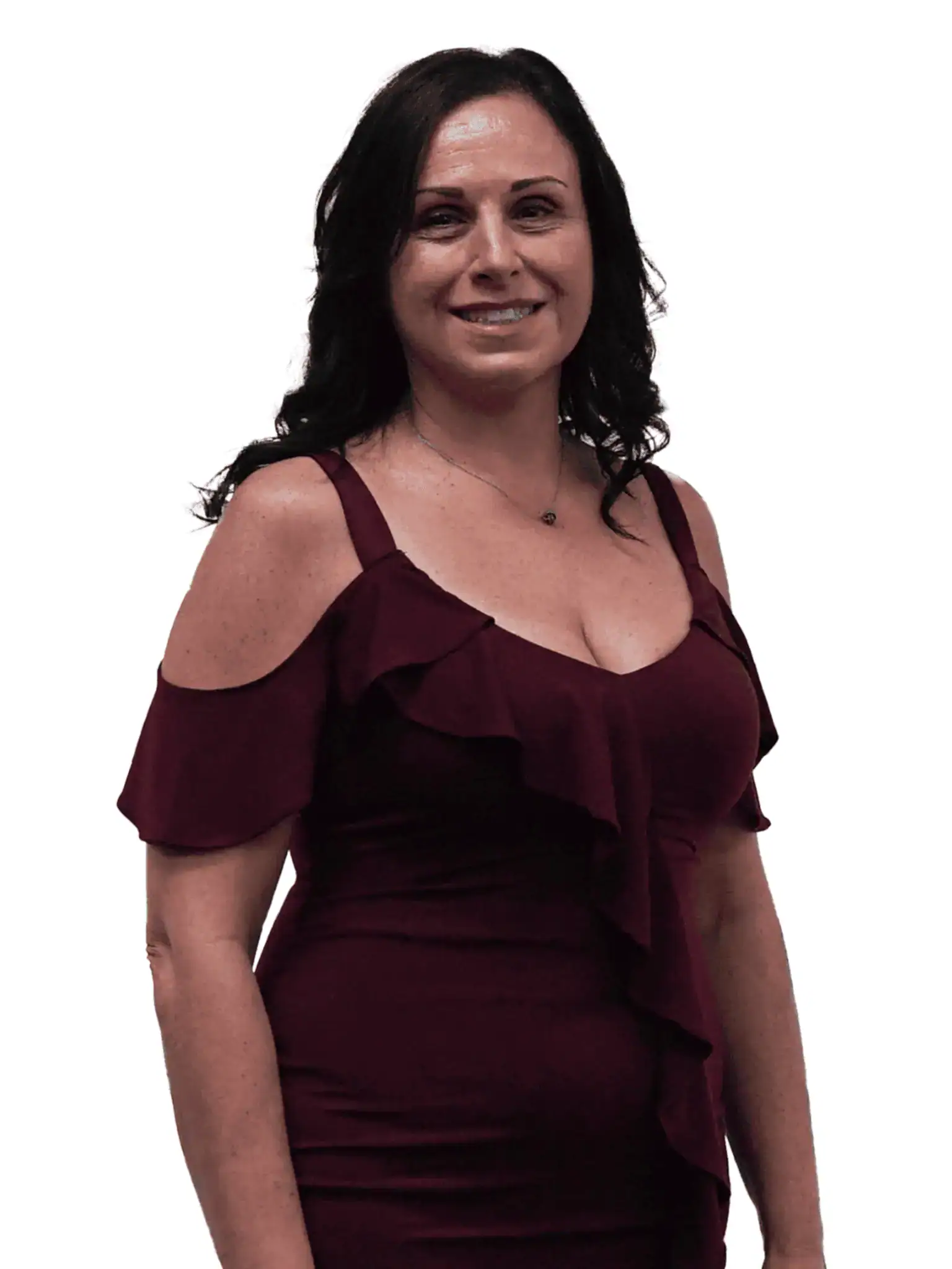 Woman with dark hair smiling, wearing a burgundy off-shoulder dress with ruffles, standing against a plain white background.