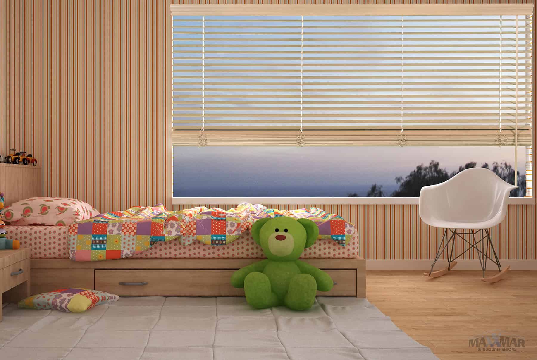A bright children's bedroom featuring a large window with blinds, a green teddy bear on the bed, and colorful patchwork bedding. The room has wooden walls and flooring, creating a warm, inviting atmos.