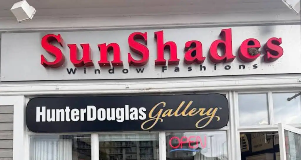 SunShades window fashion store sign with HunterDouglas Gallery logo and open sign, storefront exterior.