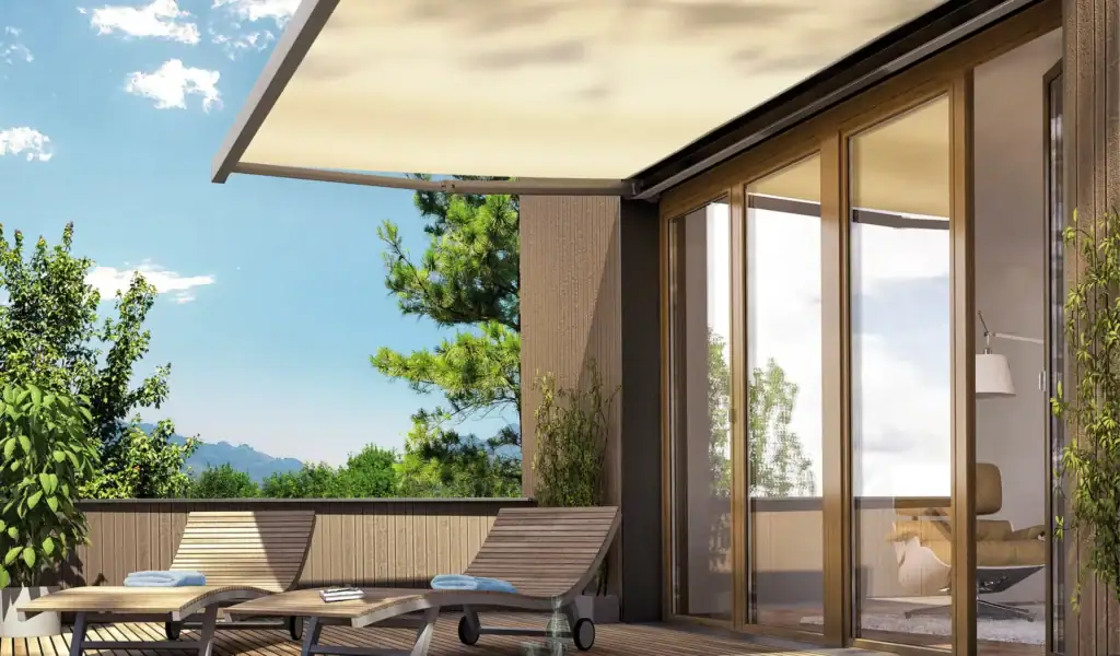 Contemporary balcony with wooden lounge chairs, glass sliding doors, and lush greenery in the background, offering a relaxing outdoor space.