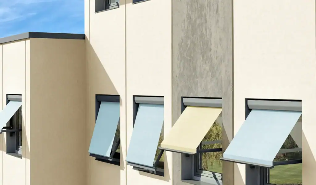 Contemporary building facade with multiple retractable awnings in different colors, providing shade and aesthetic appeal.