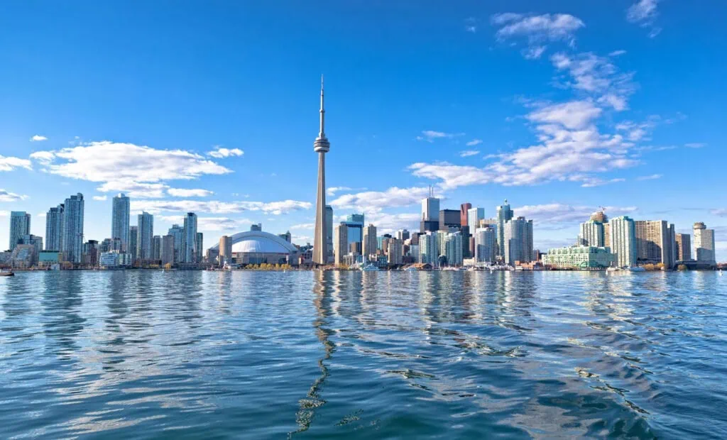 Toronto skyline with CN Tower, high-rise buildings, and waterfront on a clear day.