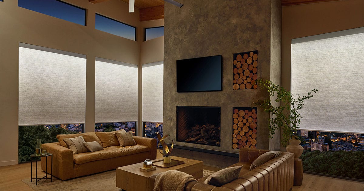 High-quality white roller window blinds installed in a modern living room with large windows, creating a sleek look and controlling natural light effectively.