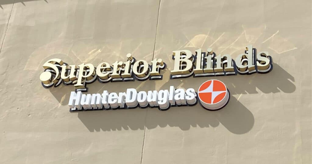 Elegant exterior sign of Superior Blinds and Hunter Douglas window treatment store with 3D lettering and logo design.