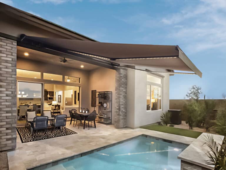 Modern outdoor patio with sleek retractable fabric awning, comfortable seating, and a sparkling pool, perfect for outdoor living and shade solutions from Superior Blinds.