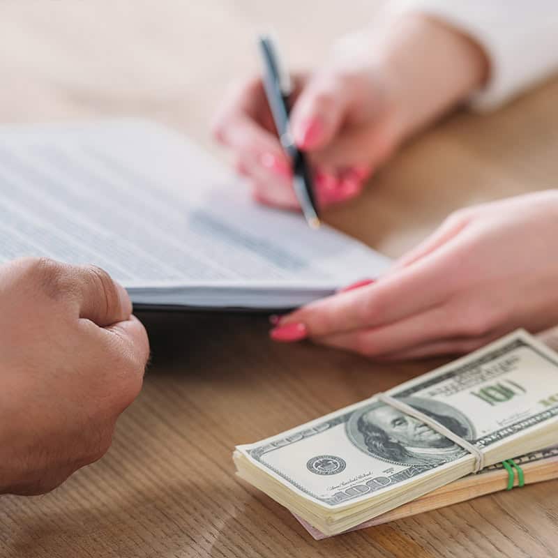 High-quality window blinds being reviewed for home or office renovation with a person signing a document in the background.
