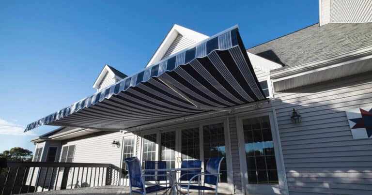Stylish retractable striped fabric patio awning providing shade and sun protection for outdoor living space. Perfect for enhancing your home’s outdoor comfort and curb appeal.