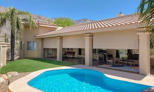 Luxurious window blinds installed on a modern house with a backyard pool, providing privacy and shade, perfect for outdoor living spaces.