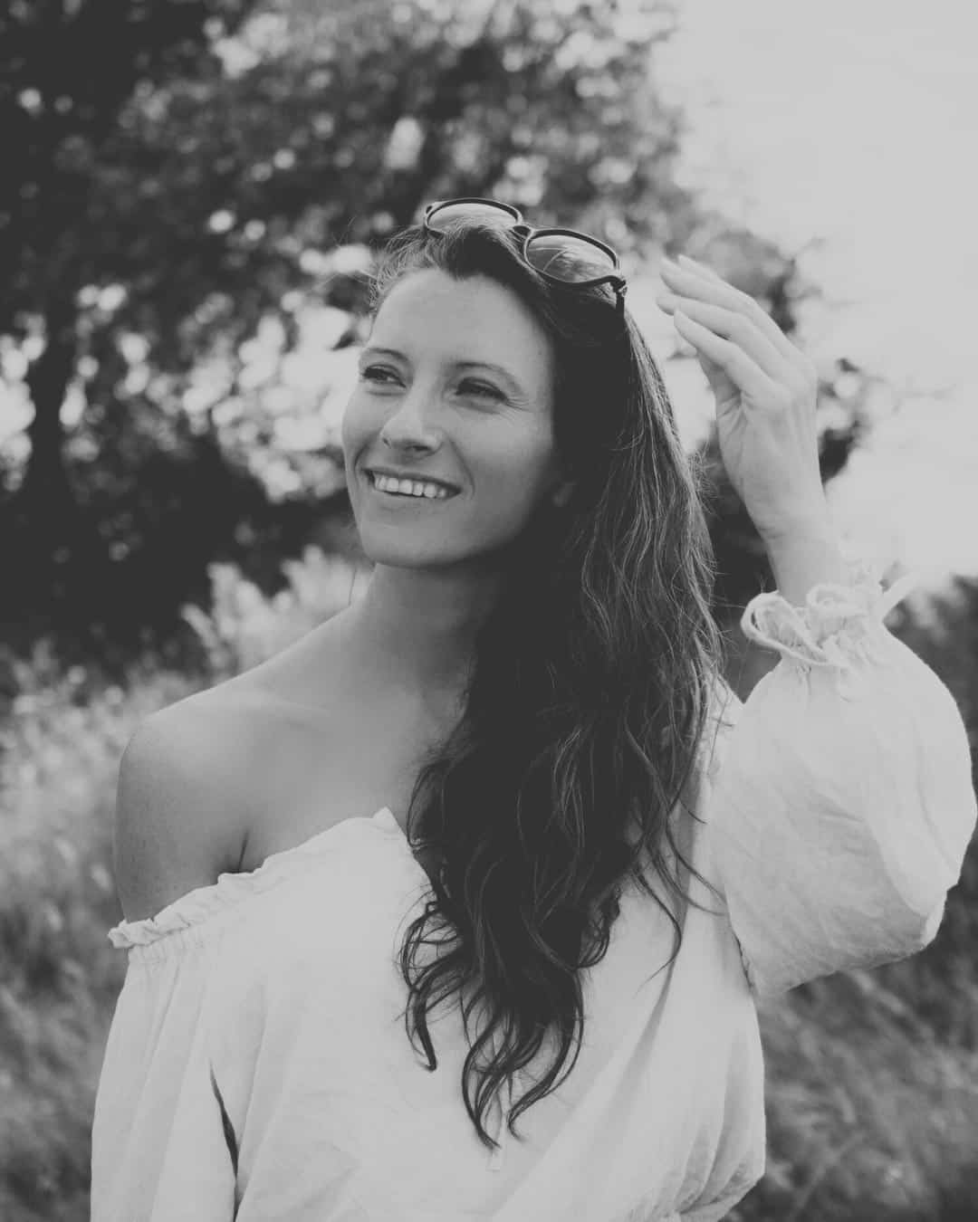 Holly Robinson, founder and intimacy coach, smiling gently in nature — embodying warmth, connection, and calm confidence.