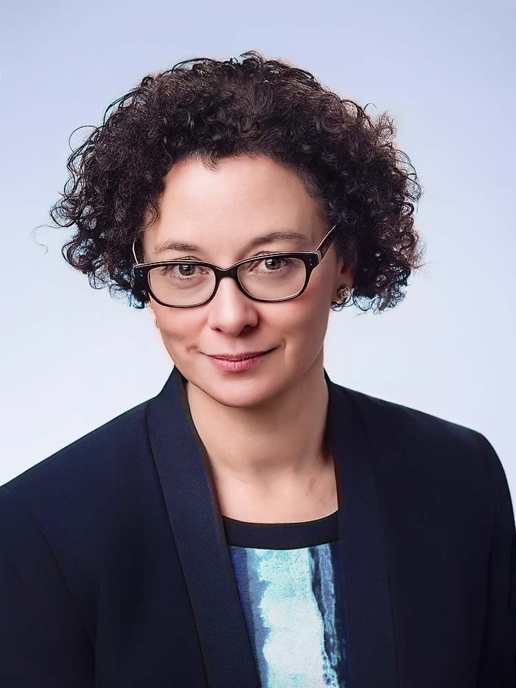 Professional Sussex headshot of a woman in business attire with glasses, perfect for corporate, LinkedIn, or personal branding.