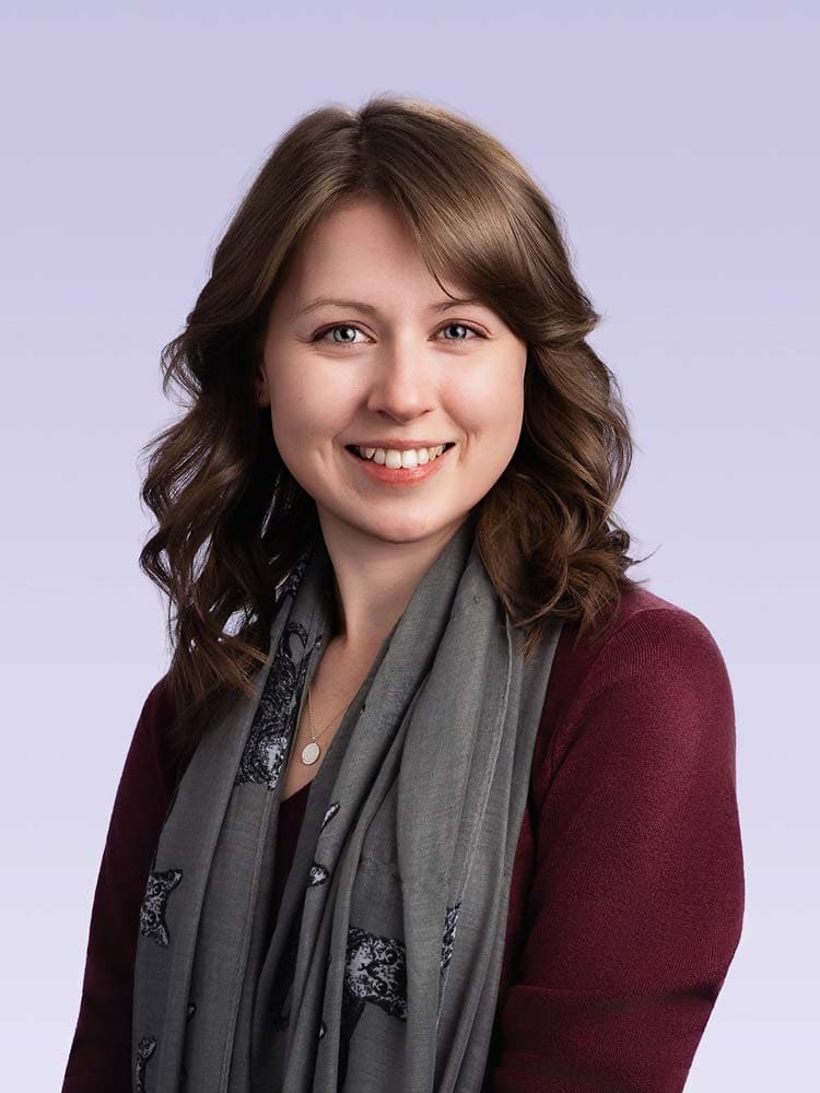 Professional Sussex headshot of a smiling woman with brown wavy hair, ideal for corporate profile pictures and personal branding in Sussex.