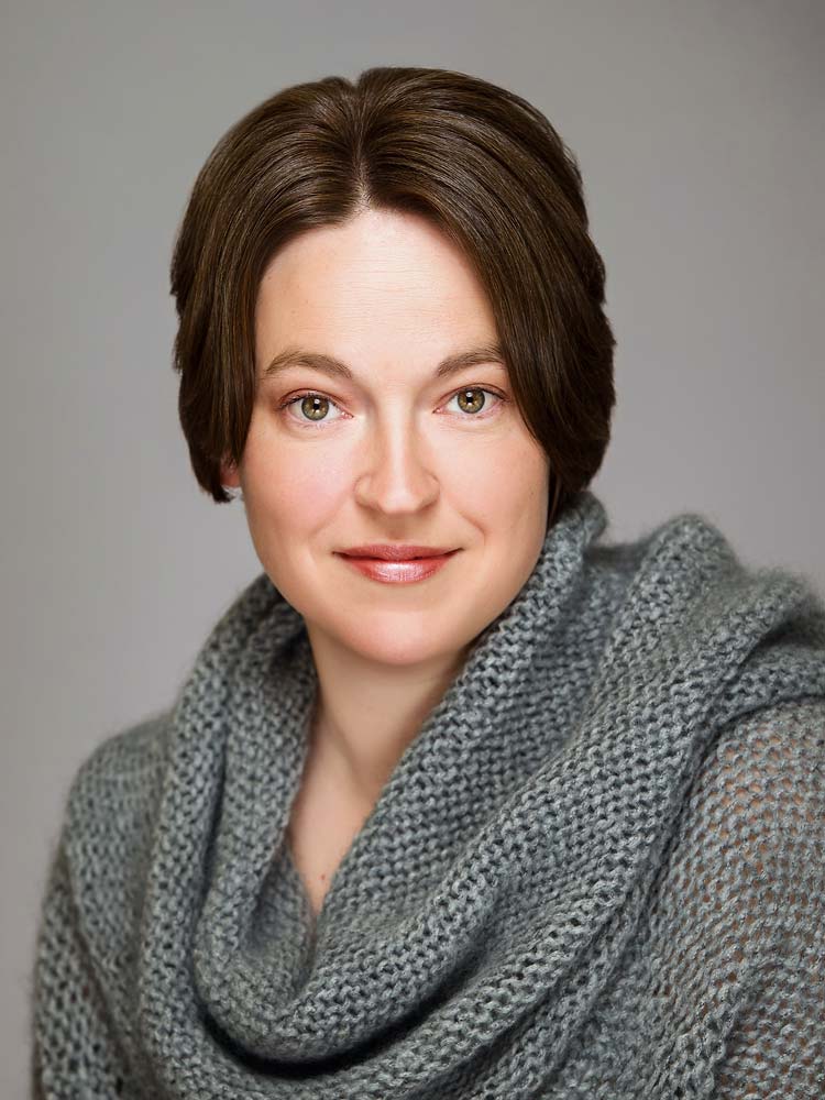Elegant professional headshot of a woman with short brunette hair, wearing a grey textured scarf, perfect for corporate and LinkedIn profiles in Sussex.