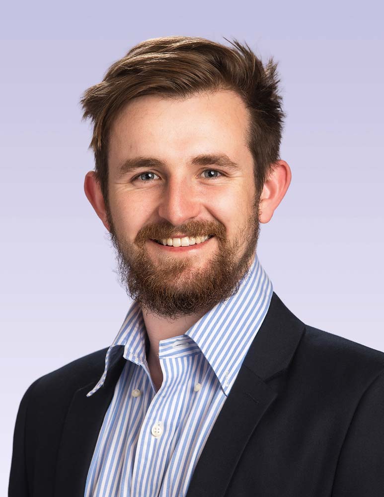 Professional Sussex headshot of a confident businessman in a navy blazer and light blue striped shirt, perfect for corporate or LinkedIn profiles.