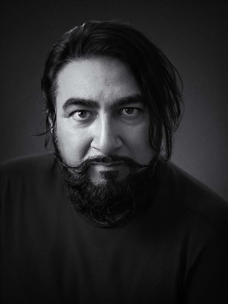 Professional black and white headshot of a man with dark hair and beard, suitable for corporate or personal branding in Sussex.