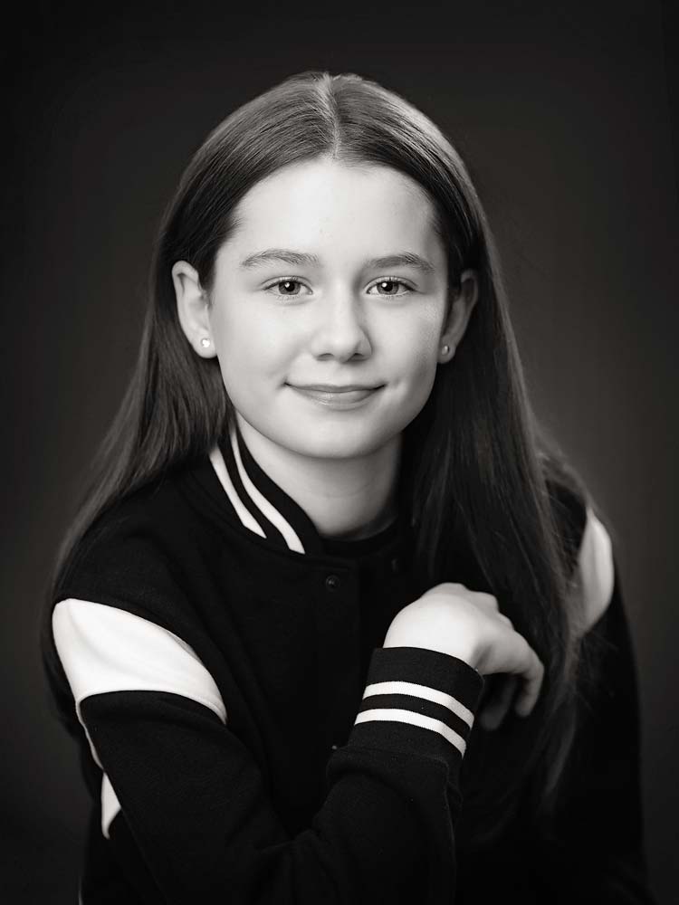 Professional Sussex headshot of a young woman in black and white, showcasing confidence and approachability for corporate or personal branding.