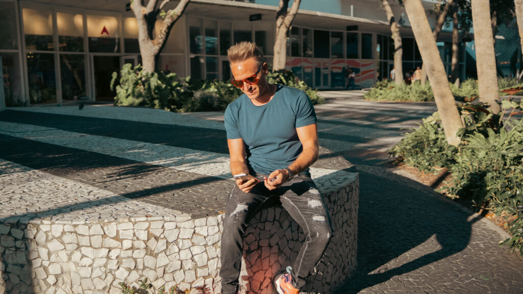 Innovative urban entrepreneur using mobile device at outdoor city park, showcasing modern business solutions and digital connectivity for startups.