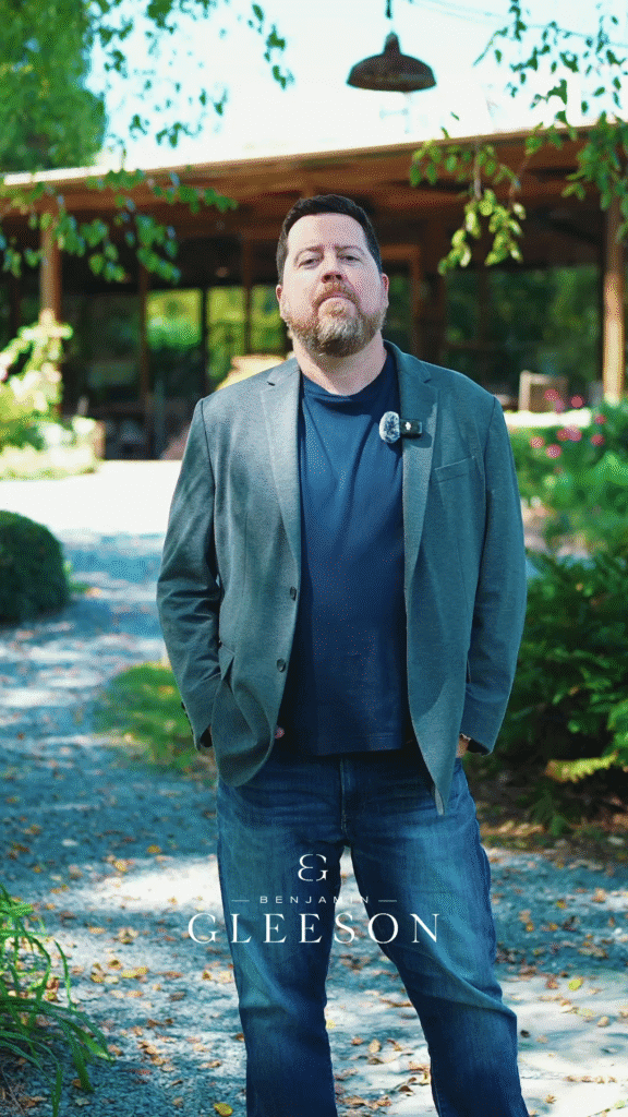 Syslo Ventures founder Benjamin Gleeson standing outdoors in a garden, wearing a blazer and jeans, promoting innovation and investment in sustainable technology, with a modern backyard setting.