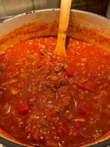 simmering chili on a stove in a dutch oven