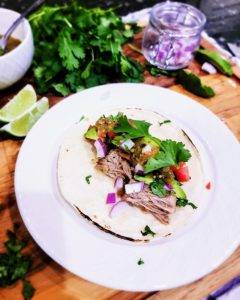 Carnitas on a toasted tortillas with fresh salsa