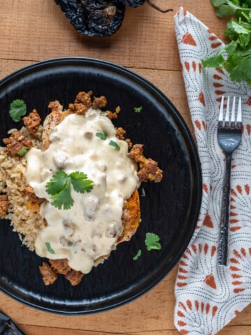 Chori Pollo plated. Chicken on a bed of rice covered in a chorizo queso sauce