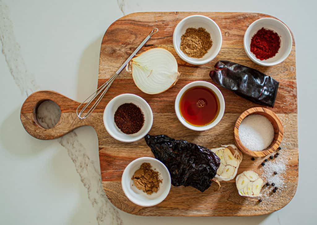 Spices and ingredients for homemade chorizo recipe on a wooden cutting board