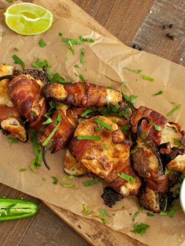 Smoked Jalapeno Poppers on parchment paper with lime and dip