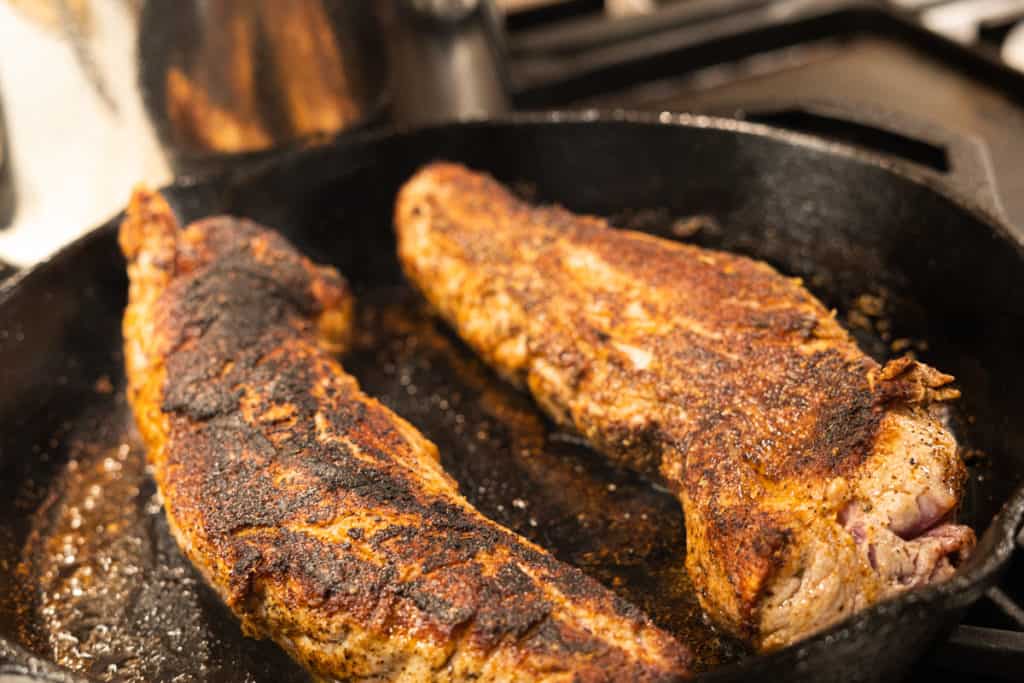 Seared pork tenderloin with a browned crust on all sides ready for the smoker