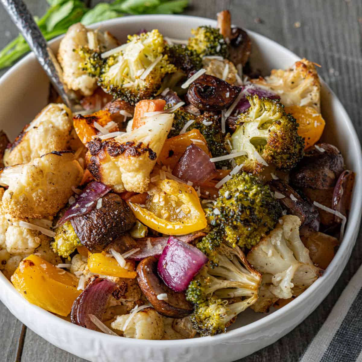 Colorful smoked vegetables including broccoli, cauliflower, and peppers in a bowl.