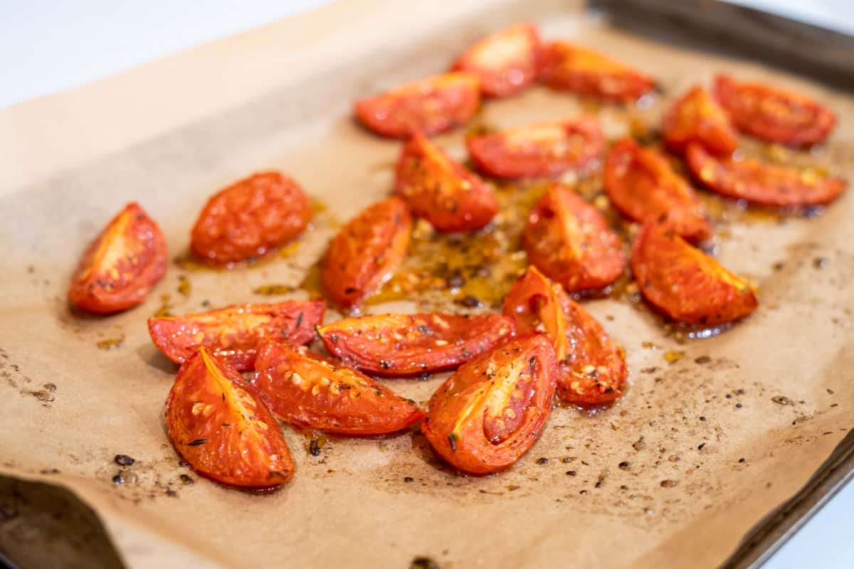 Roma tomatoes quartered on a sheet tray