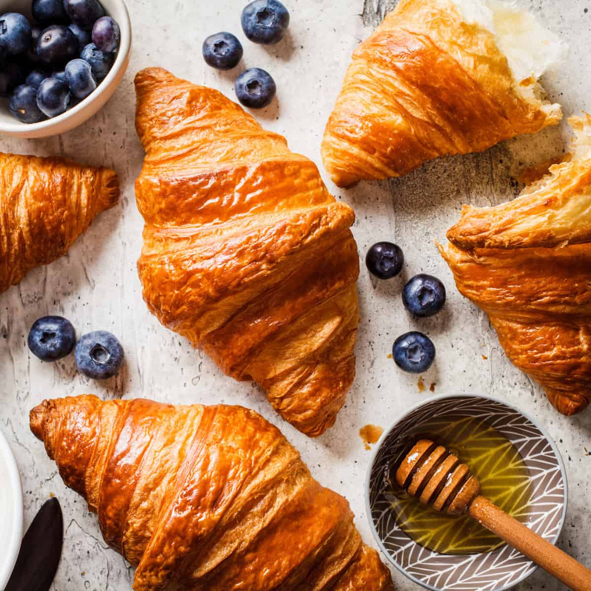 croissants in a table with fresh blueberries and honey