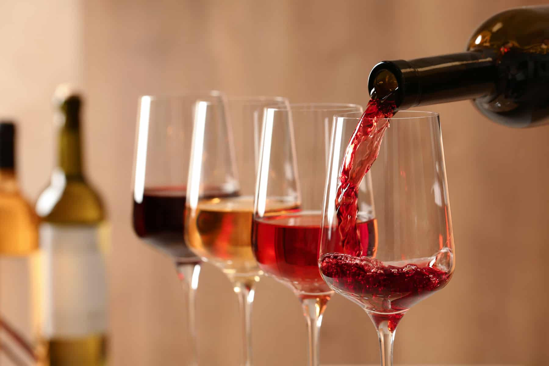 4 glasses of wine filled with 4 different colors of wine