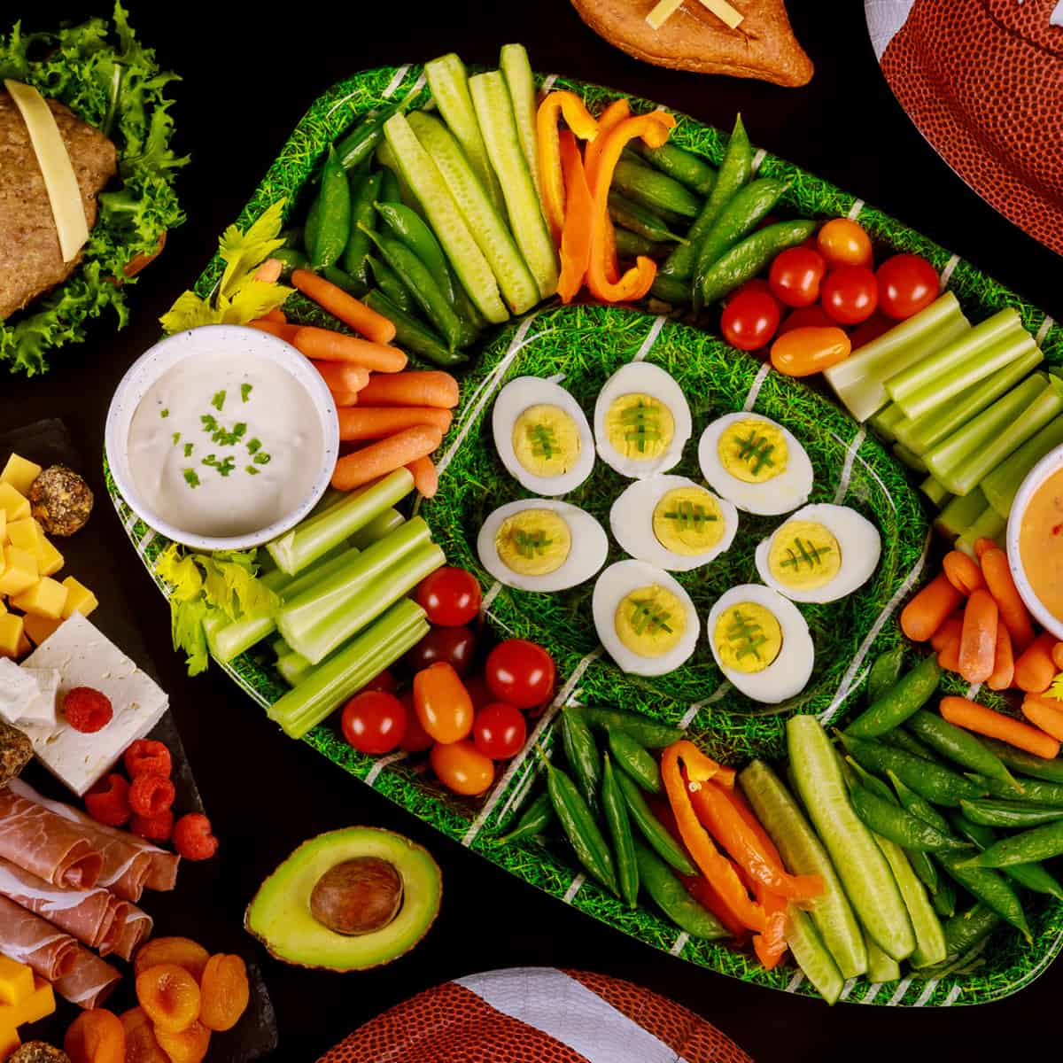 Football Charcuterie Board with deviled eggs in the center and veggies in the "stands"
